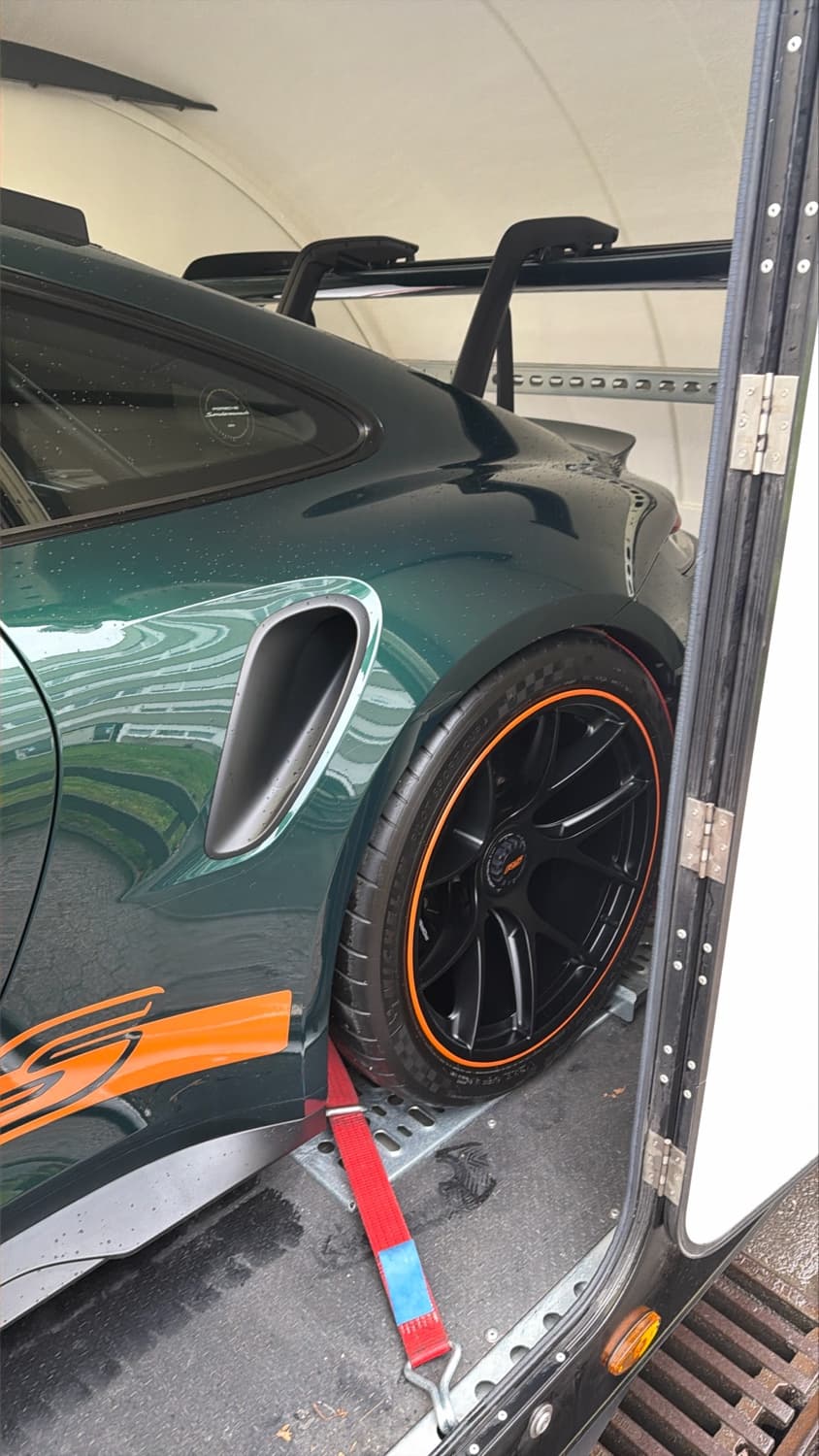 Porsche 911 GT3 RS verte arrimée dans remorque Brian James